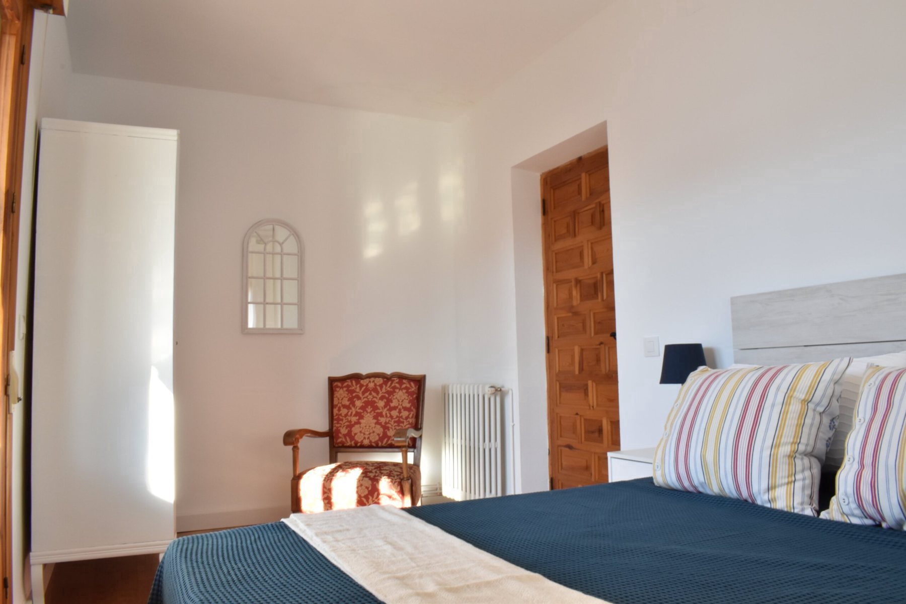 Habitación de matrimonio con mesilla y ventana