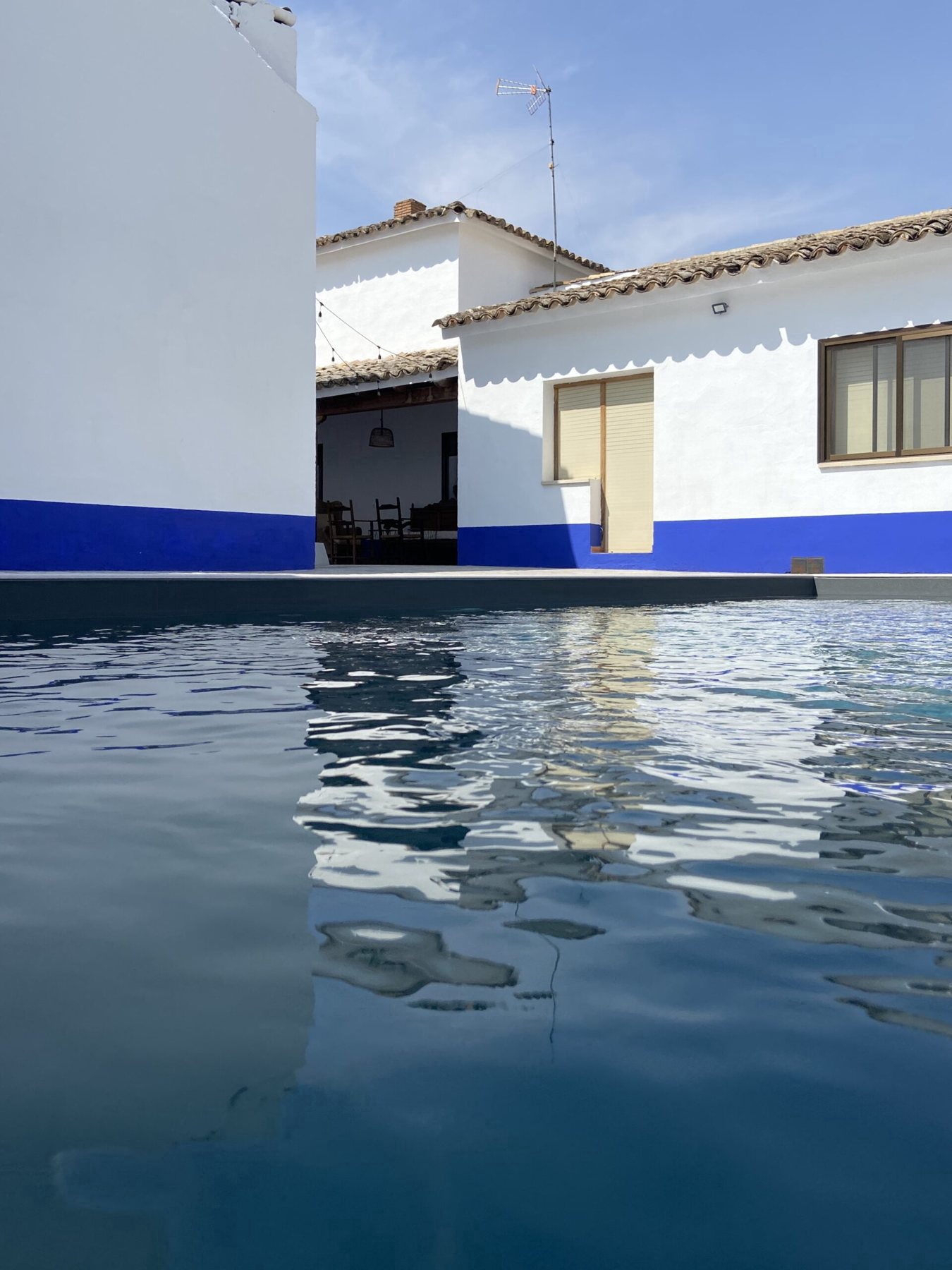 El agua de la piscina junto al patio